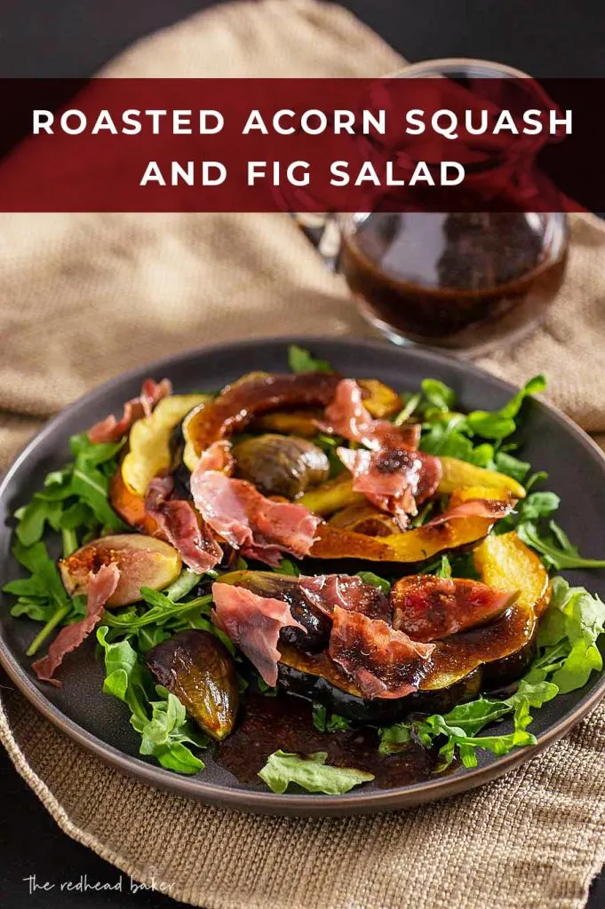 A plate of acorn squash and fig salad in front of a jug of balsamic vinaigrette