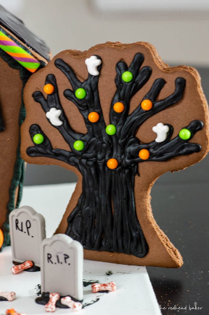 Wilton makes it easy to create a spooky haunted Halloween cookie house with kits, which includes pre-made cookie house pieces, trees, and candy decorations. You can also incorporate other Wilton products! #HalloweenTreatsWeek