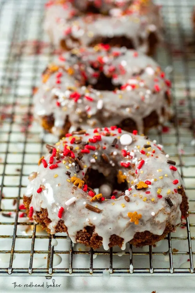 A wire rack of iced baked gingerbread donuts