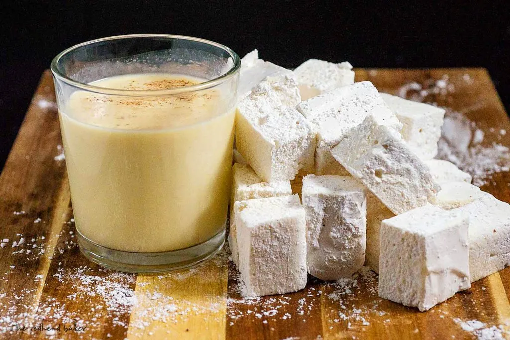 A glass of eggnog with a pile of eggnog marshmallows