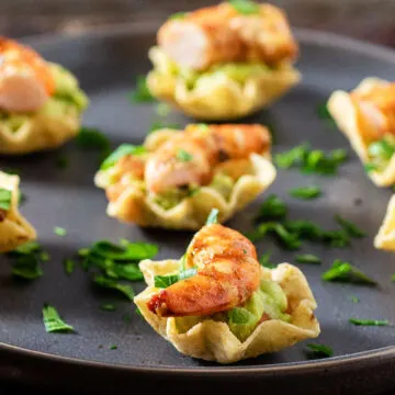 Recado Rojo Shrimp Guacamole Bites on a black plate.