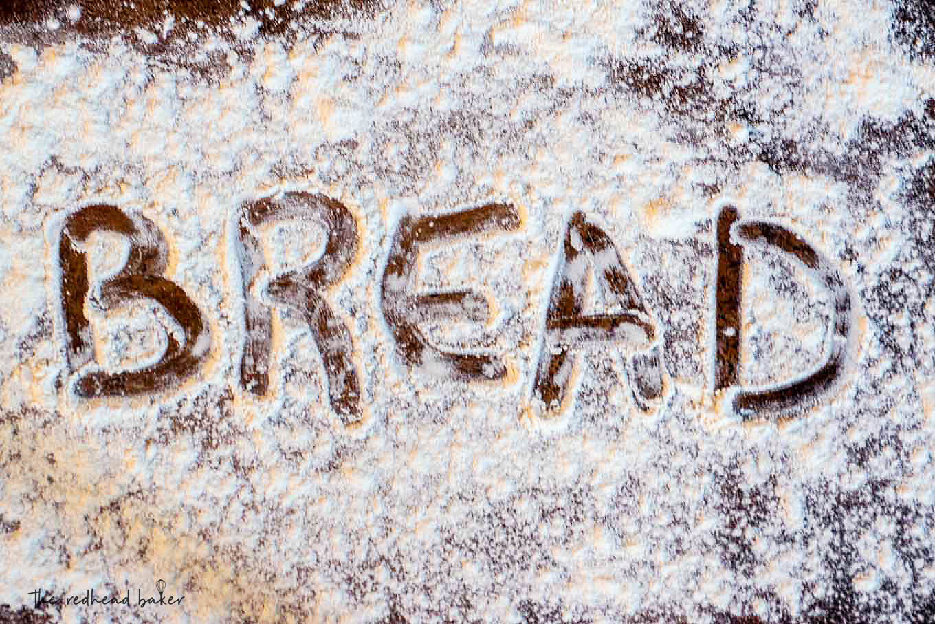 The word "bread" written in flour on a sheet pan.