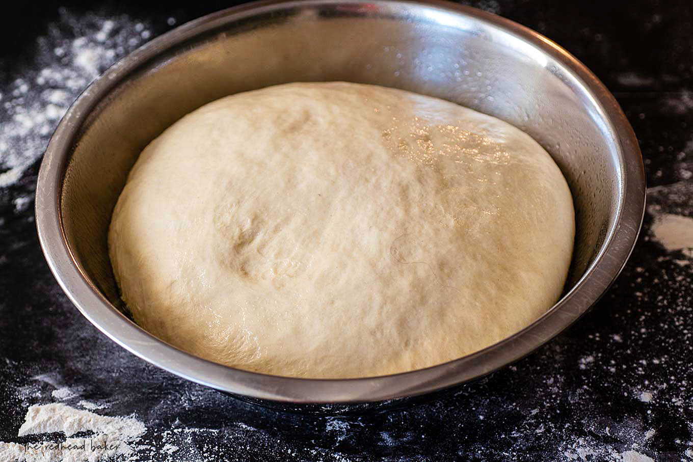 A bowl of fully risen Italian bread dough.