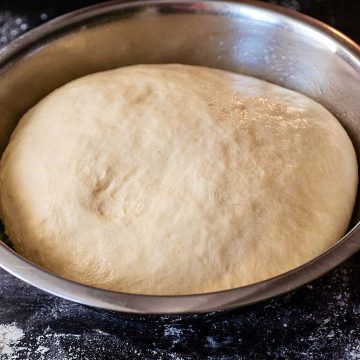 A bowl of fully risen Italian bread dough