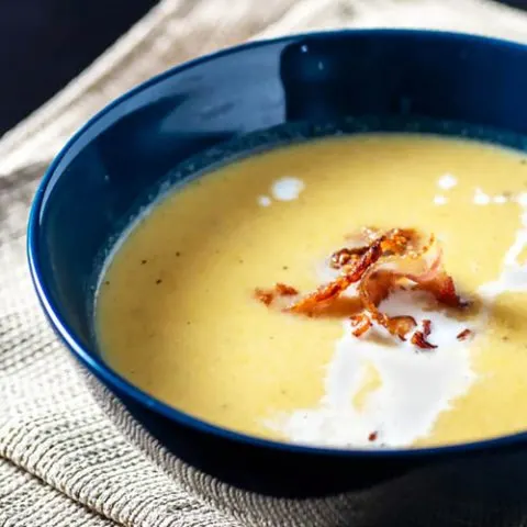 Roasted Butternut Squash Bisque is a smooth and creamy soup flavored with squash, apples, and herbs. A crispy bacon garnish gives contrasting texture.