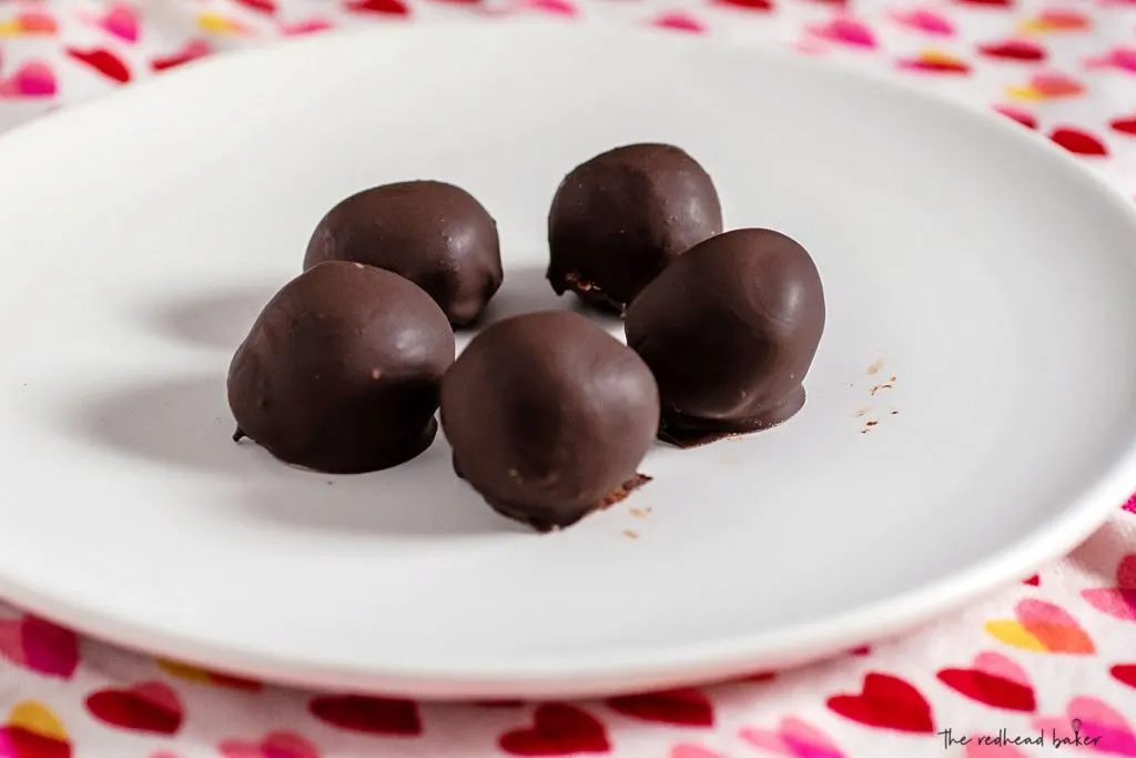 Five truffles on a white plate