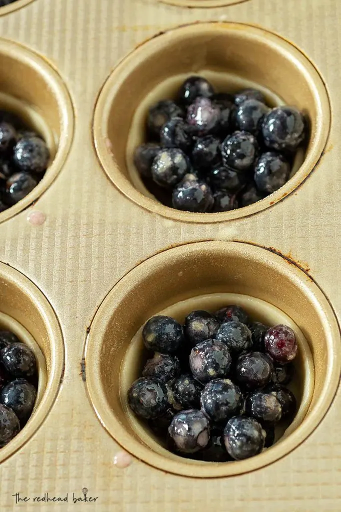 Unbaked mini blueberry pies in a muffin pan