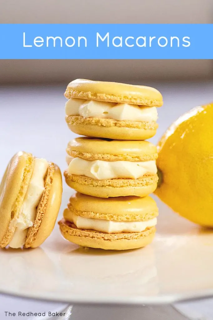 A stack of three lemon macarons in front of a lemon wedge