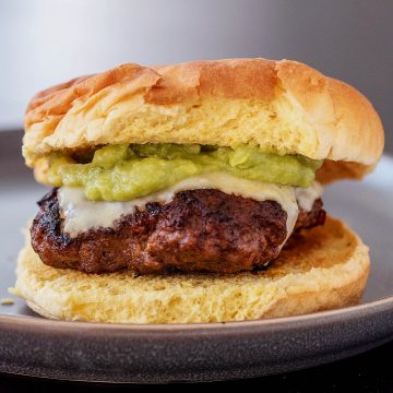 A chipotle guacamole burger on a dark gray plate