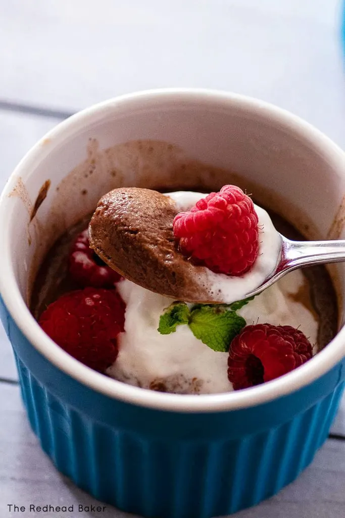 A spoonful of chocolate custard topped with a raspberry