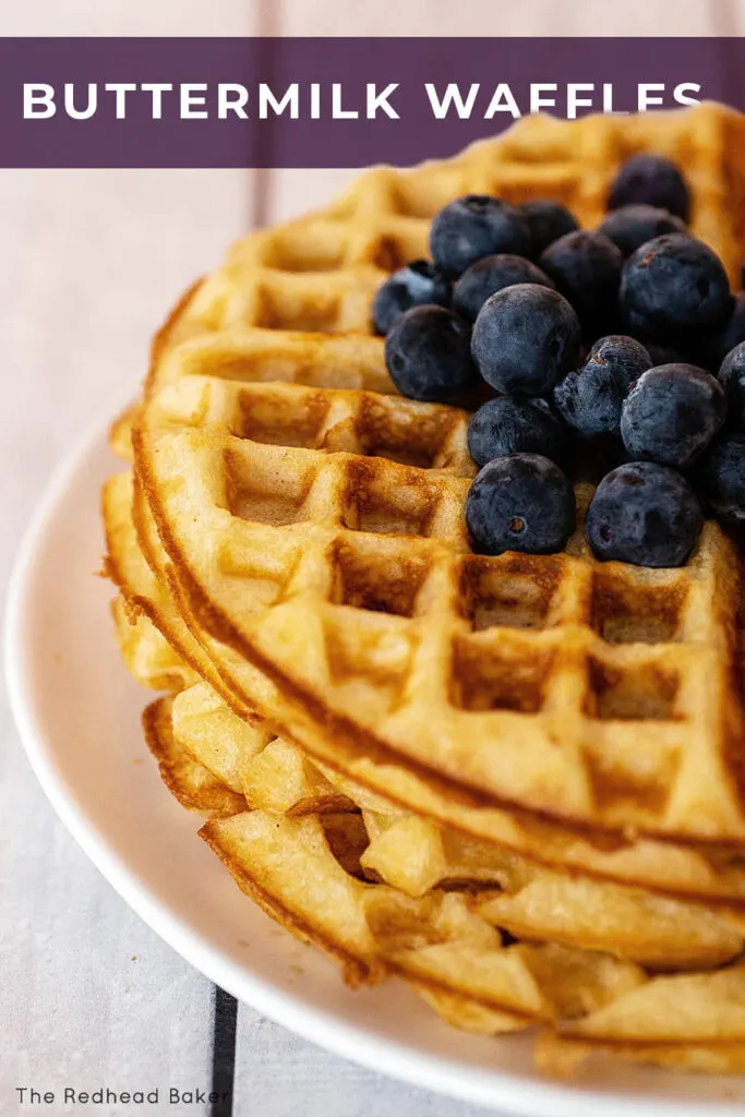A close-up of a stack of buttermilk waffles topped with blueberries