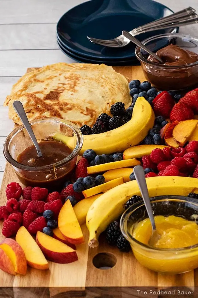 A side view of a crepe board next to a stack of plates