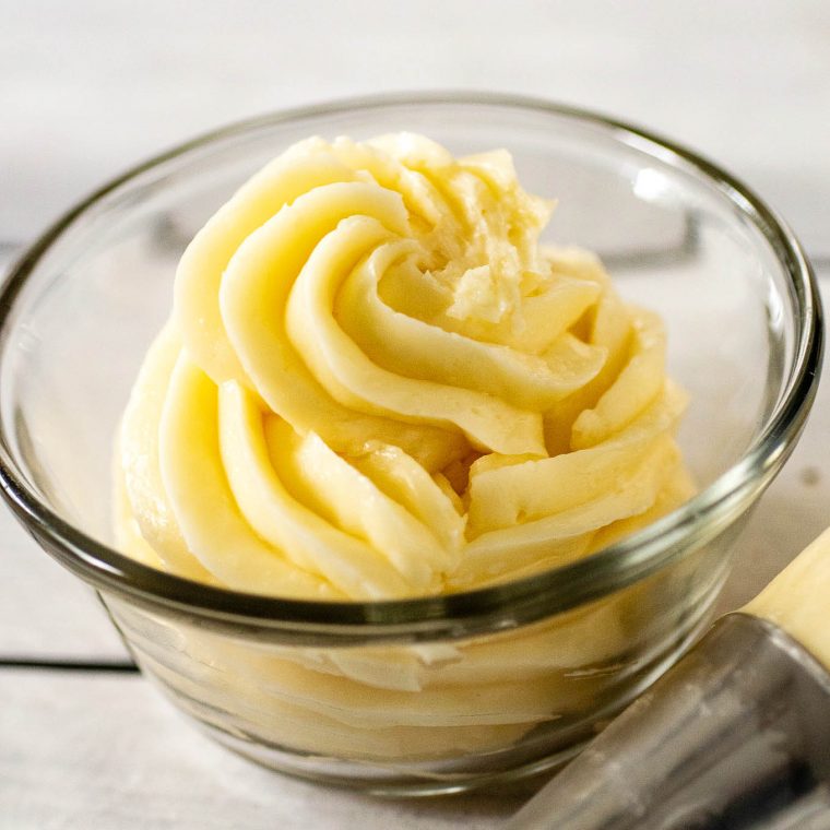 A swirl of Swiss meringue buttercream in a clear glass bowl