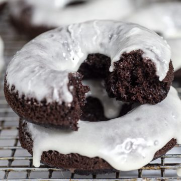 A baked glazed chocolate donut with a bite taken out
