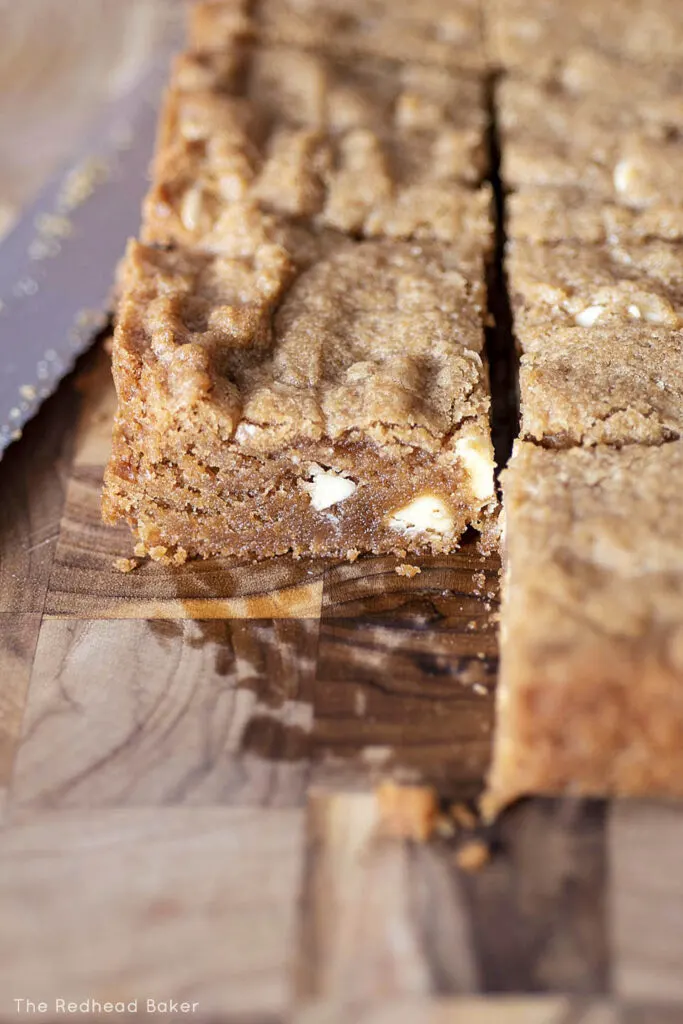 A side view of cookie butter blondies on a cutting board