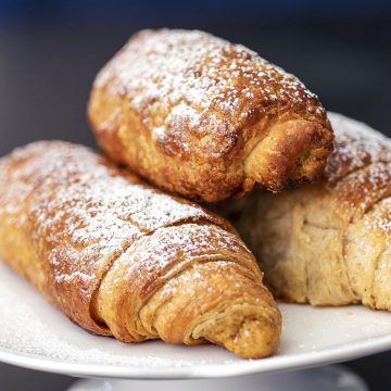 Three pumpkin croissants dusted with powdered sugar