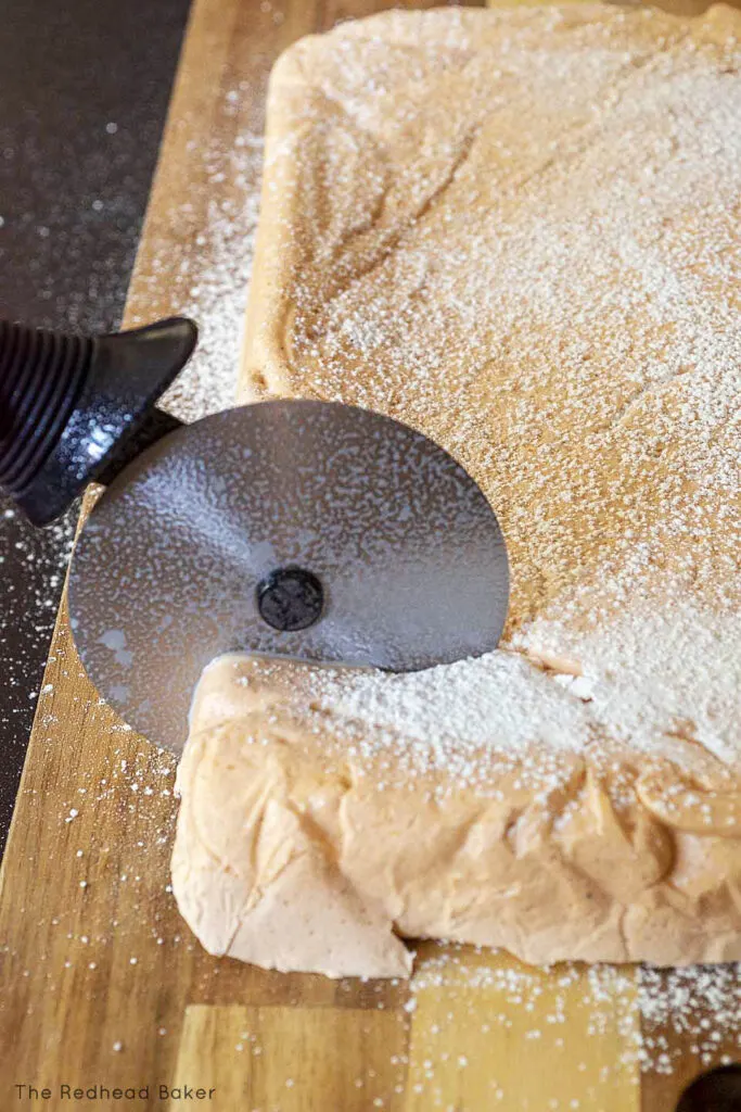 Cutting a sheet of marshmallow with a pizza cutter