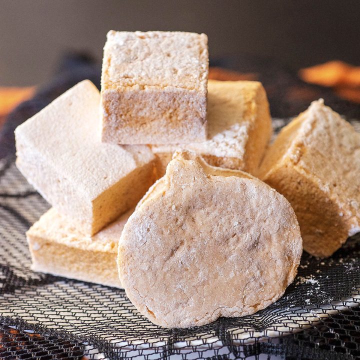 A pile of pumpkin marshmallows on a mini cake stand