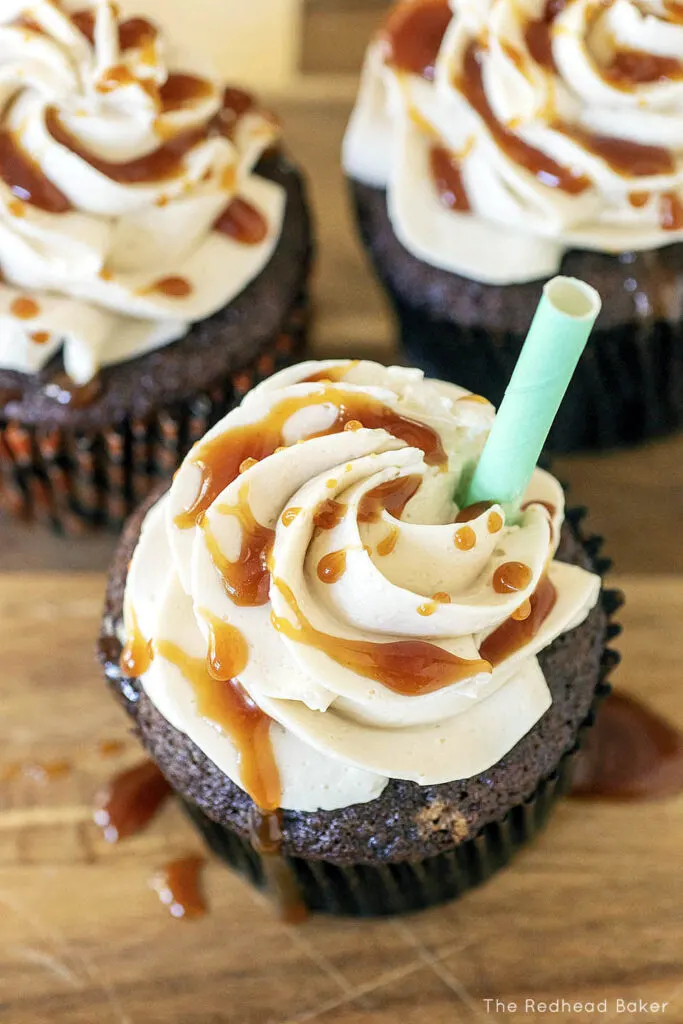 An overhead view of three frosted pumpkin spice latte cupcakes