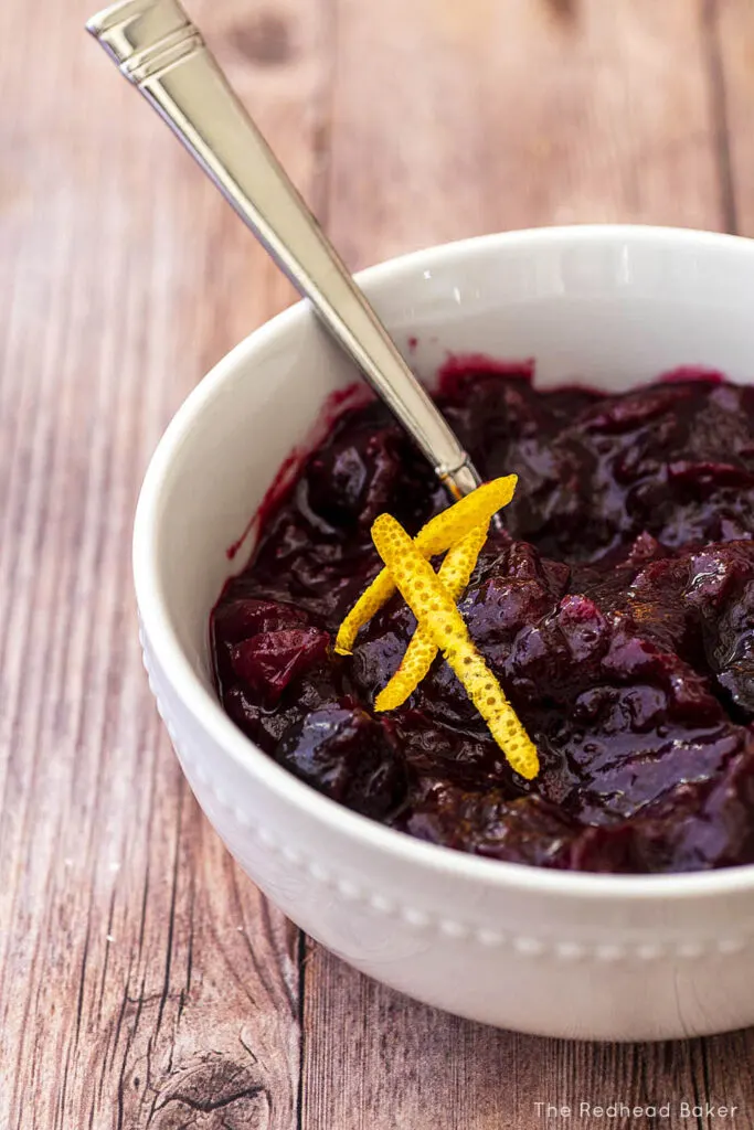 A bowl of cherry cranberry sauce topped with orange zest