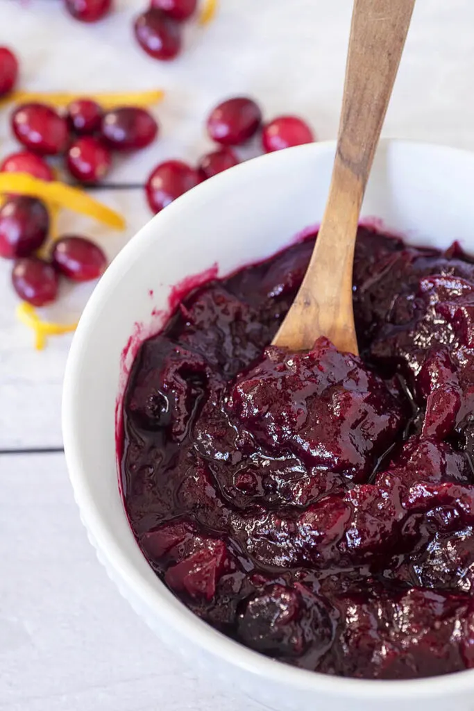 An overhead view of a bowl of cherry cranberry sauce in a white bowl