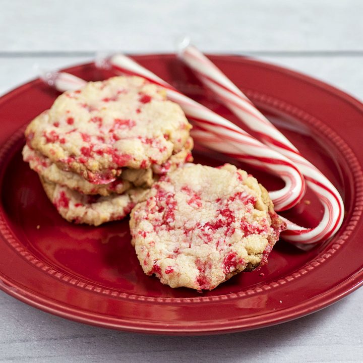 White chocolate cookies on a red plate with three cnady canes