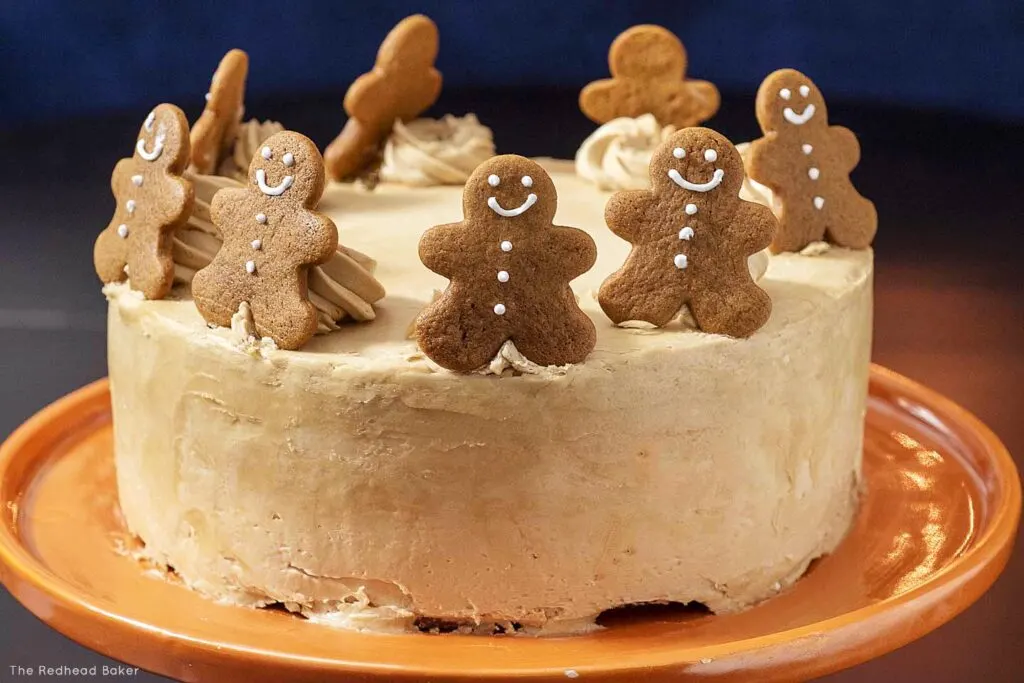 A gingerbread layer cake on an orange cake stand