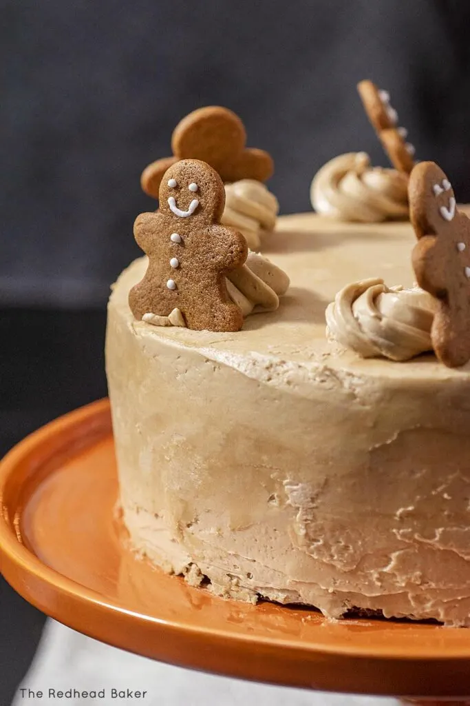 A close-up view of a gingerbread layer cake topped with mini gingerbread men cookies