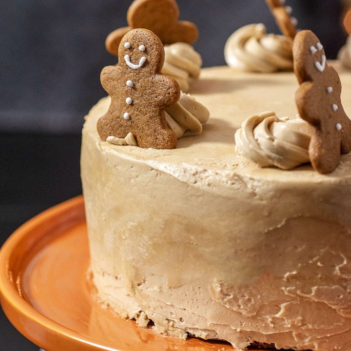 A close-up view of a gingerbread layer cake topped with gingerbread men cookies