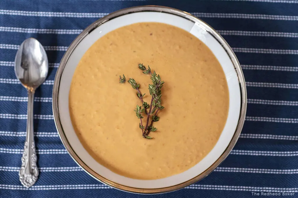 An overhead view of a bowl of lobster bisque garnished with thyme