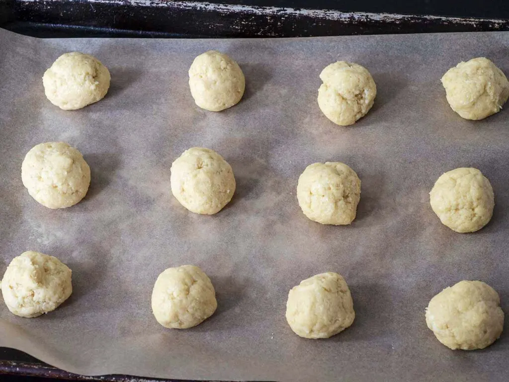 Balls of rolled dough on a baking sheet.