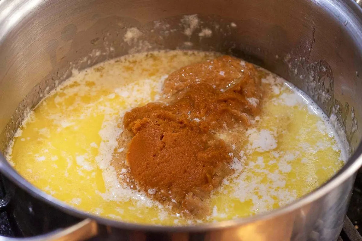 A saucepan with milk, melted butter, pumpkin, salt and nutmeg. 