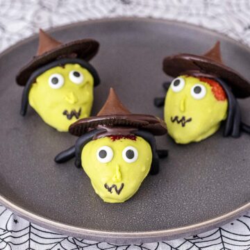 Three strawberry witches on a black plate.