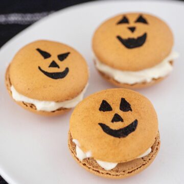 Three Halloween macarons on a white plate