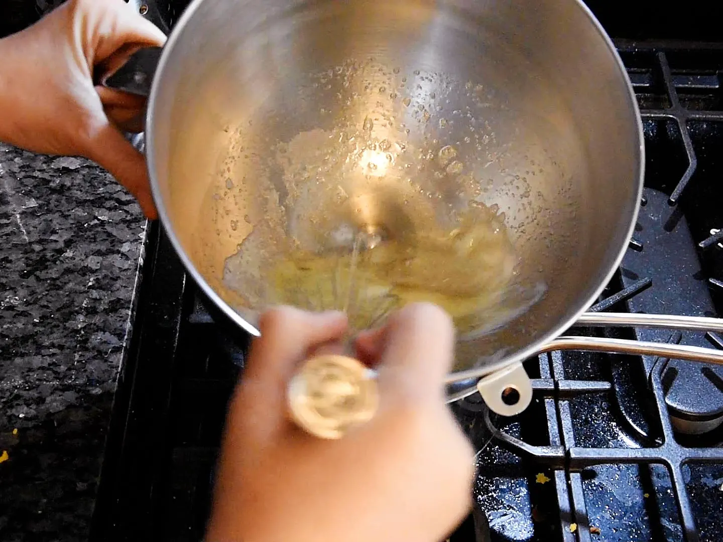 Whisking egg whites and sugar over a double boiler.