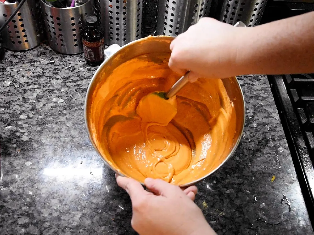 Finishing combining the meringue and almond flour by folding with a spatula by hand.