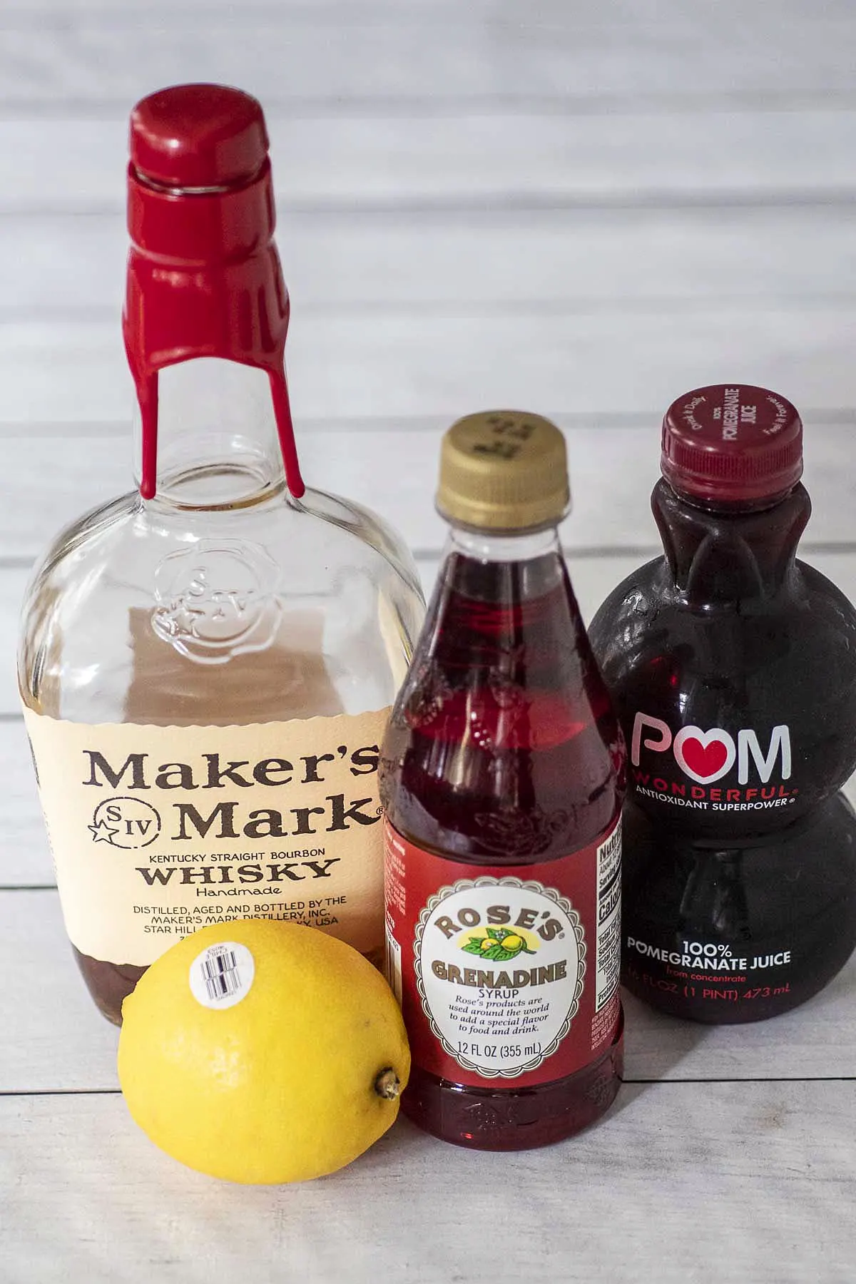 Ingredients for a witches' brew whiskey sour: whiskey, lemon, grenadine and pomegranate juice.