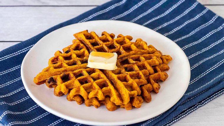 Two pumpkin waffles on a white plate.