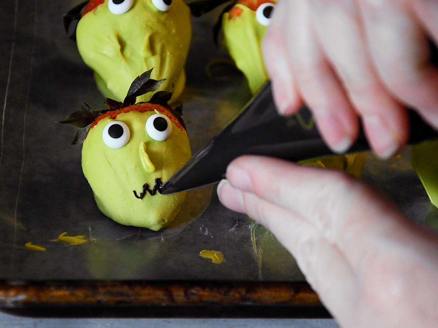 Strawberry witches step 3: draw mouths with black cookie icing.