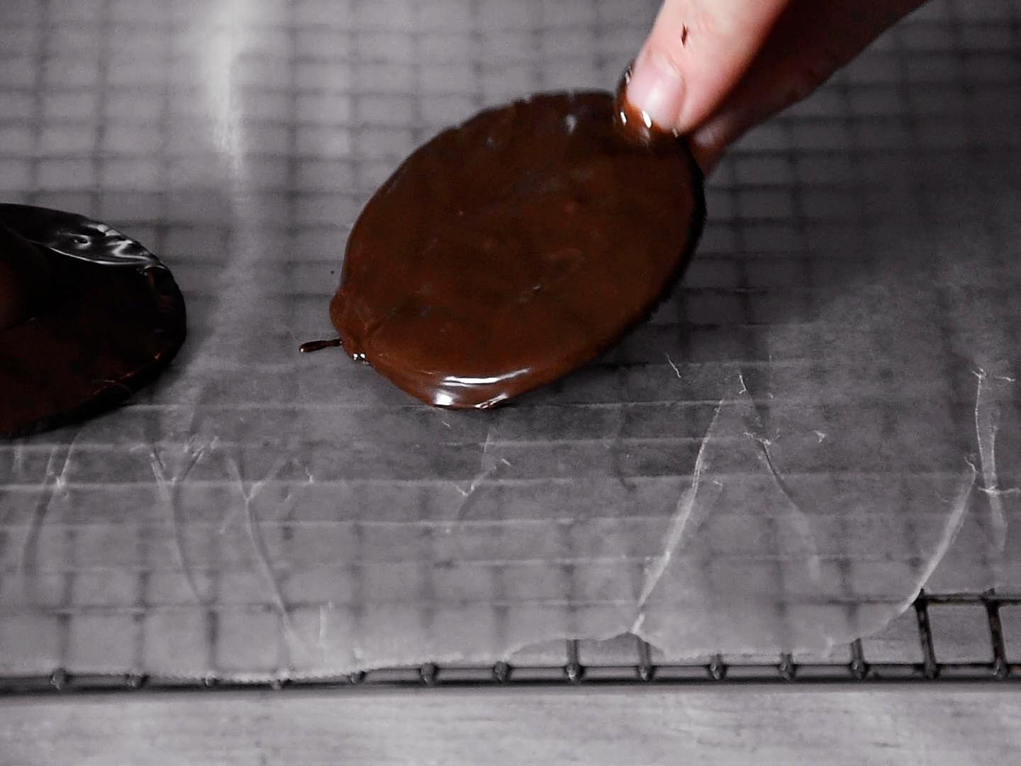 Strawberry witches step 4: dip wafer cookies in chocolate and attach a Hershey Kiss to make a hat.