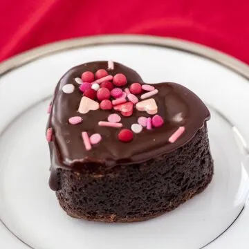 Chocolate covered brownie heart on a white plate.