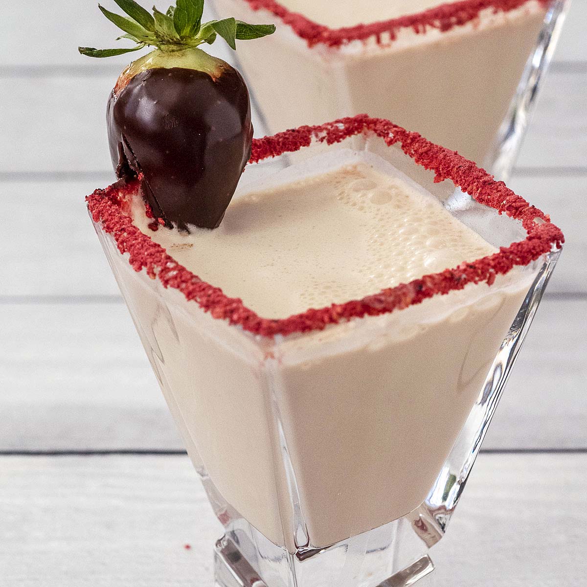 A chocolate-covered strawberry martini garnished with a chocolate-covered strawberry.