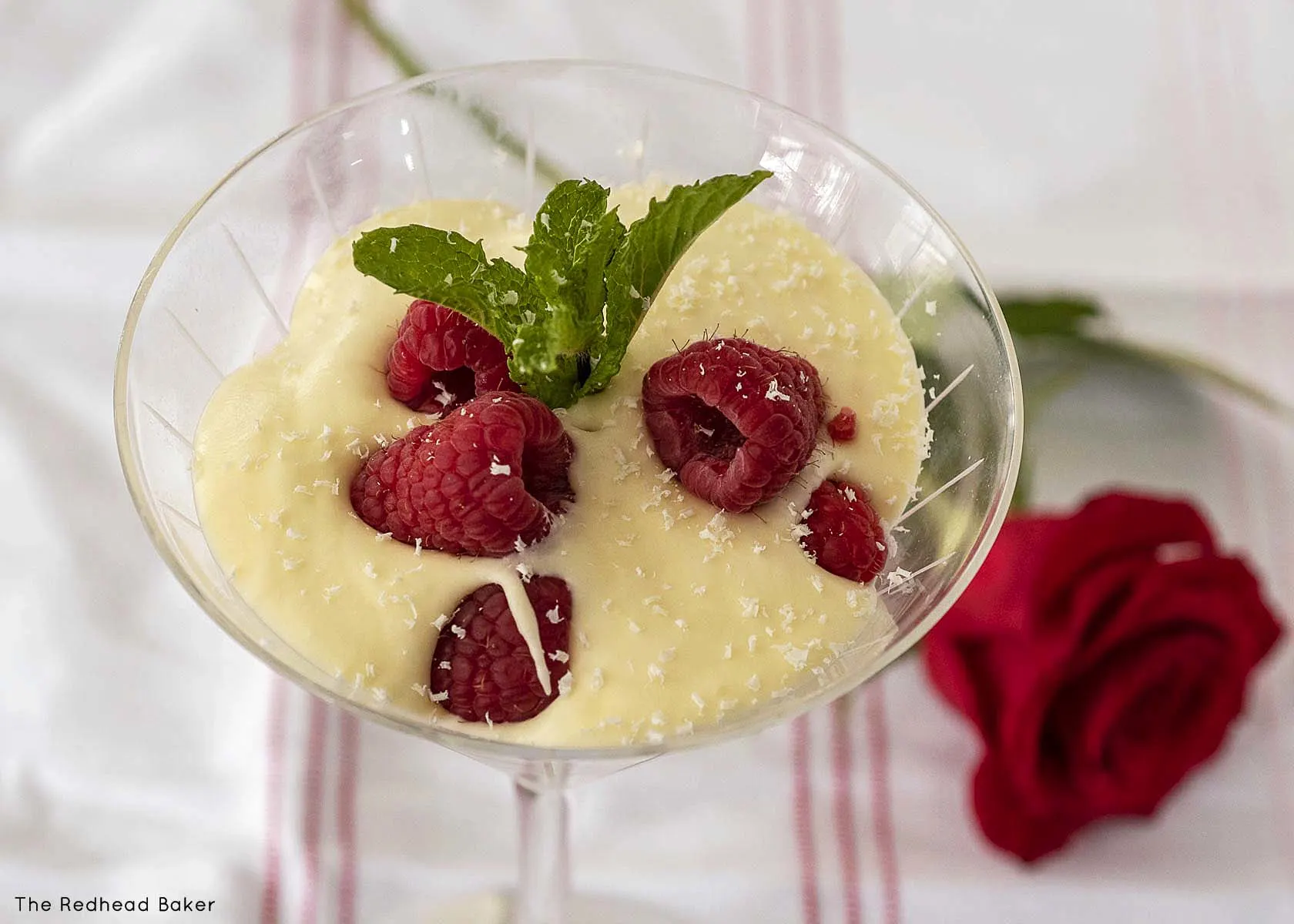 Mousse in a martini glass garnished with a sprig of mint.