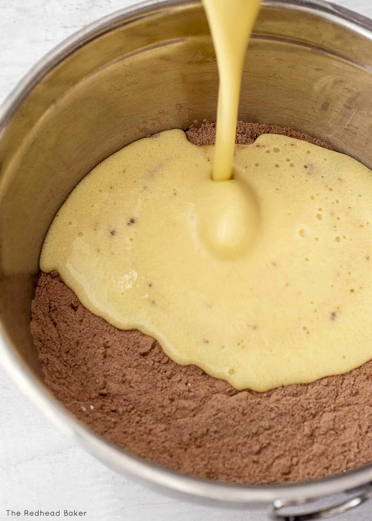 Pouring the wet ingredients into the dry ingredients.