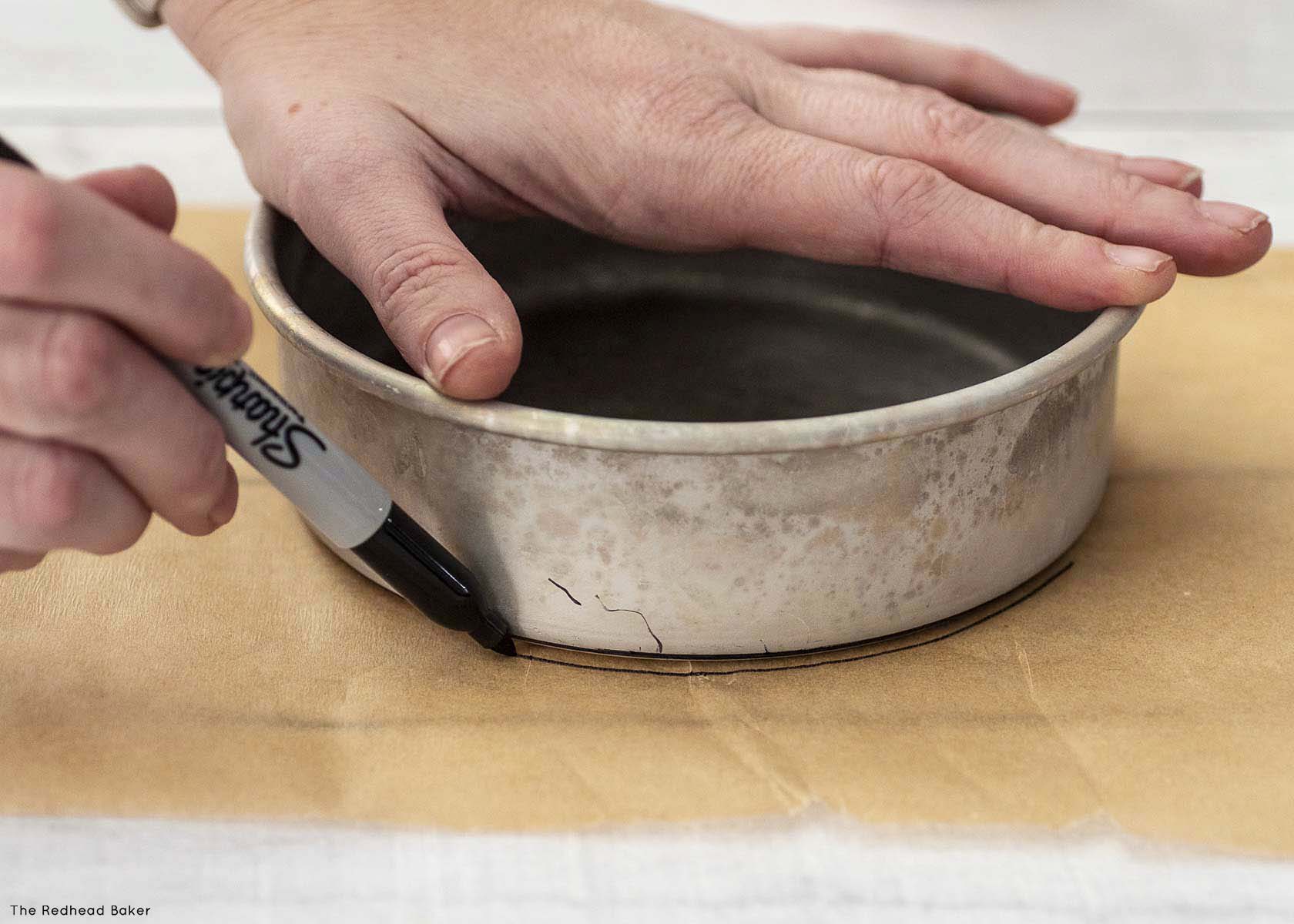 Making a parchment circle by tracing the outside edge of the cake pan.