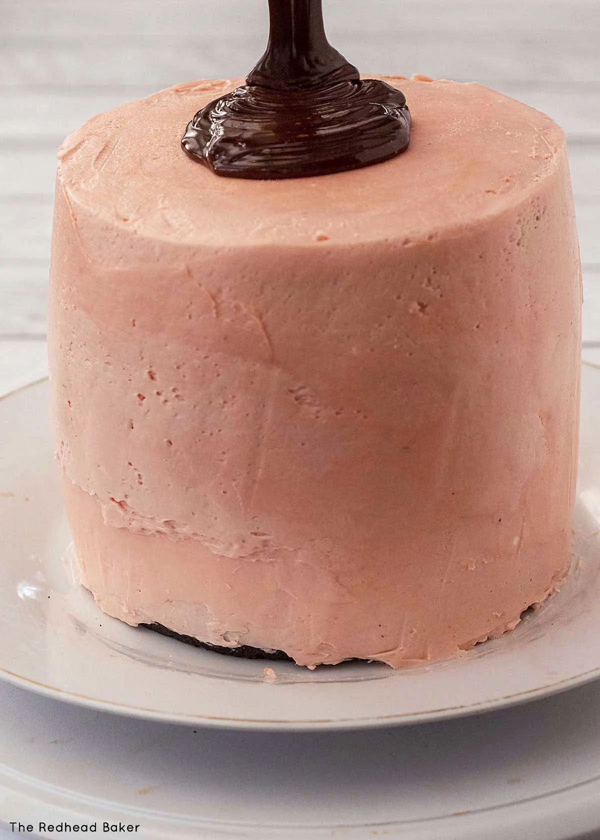 Ganache being poured onto a frosted cake.