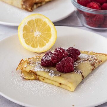 Lemon crepes garnished with raspberries.