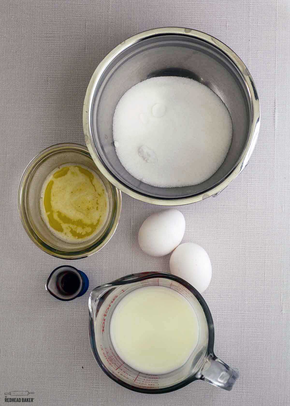 Wet ingredients for the donuts: sugar, melted butter, large eggs, vanilla extract and buttermilk.