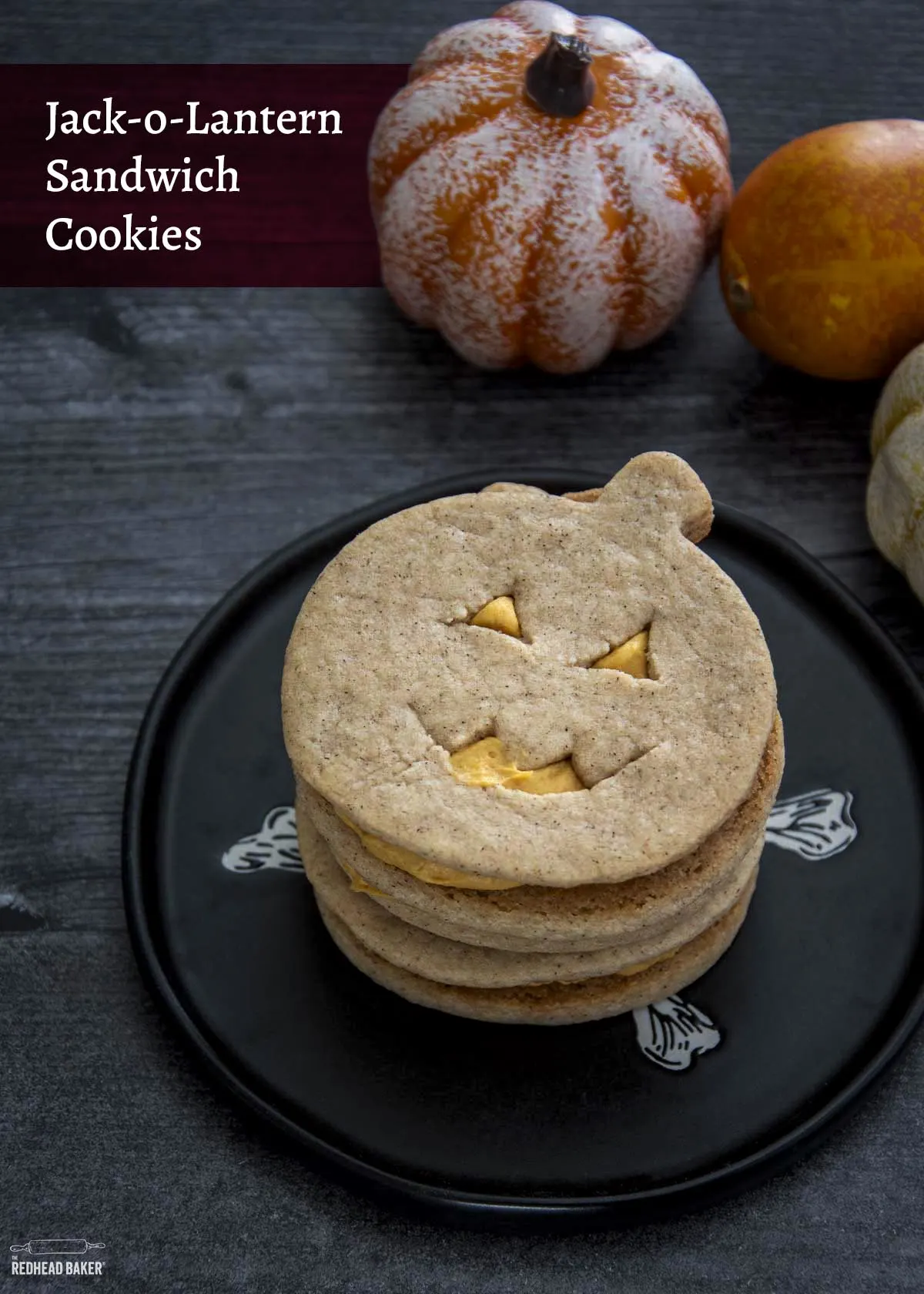 A stack of jack-o-lantern sandwich cookies on a black plate.
