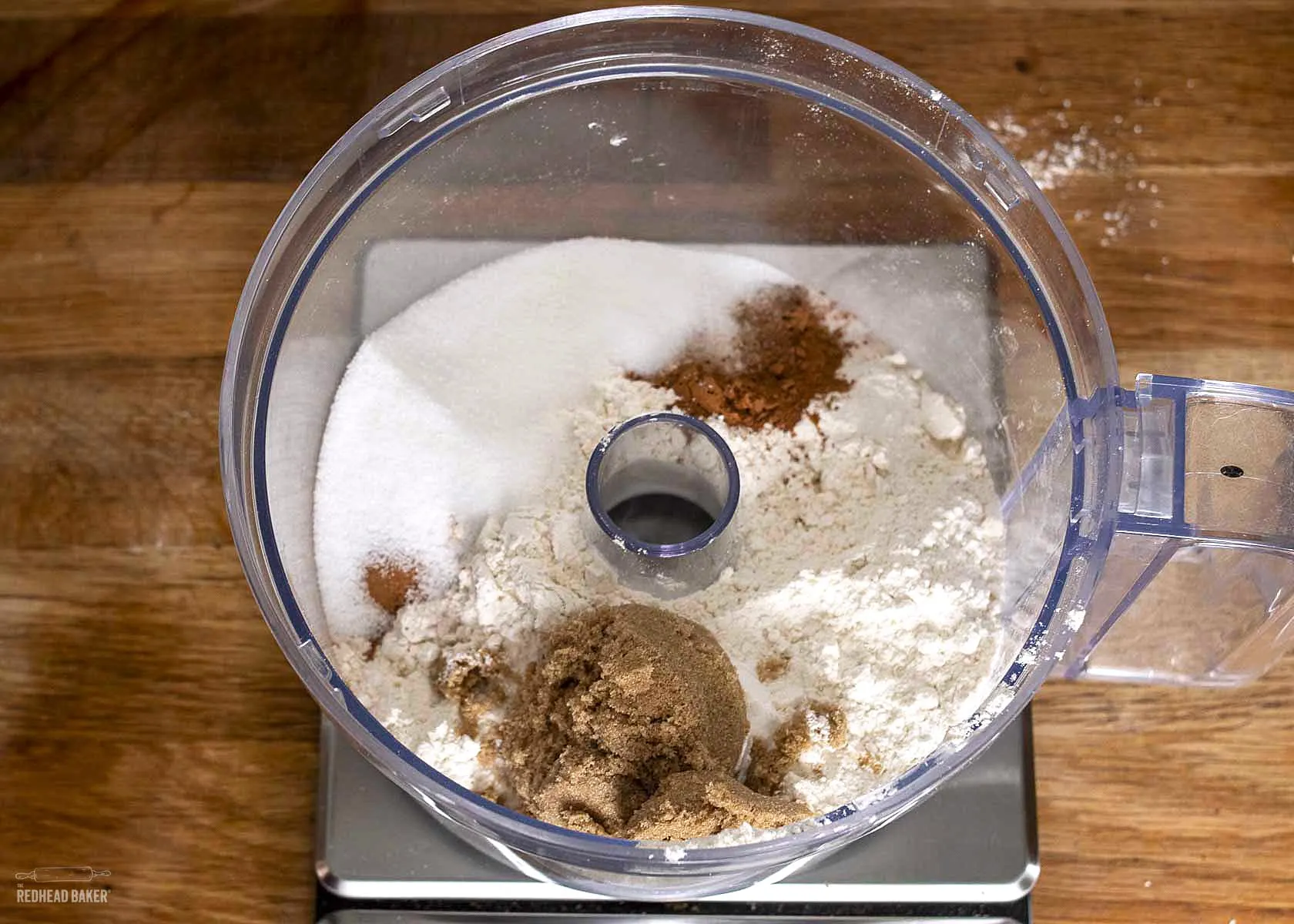 Dry ingredients for pumpkin scones in the bowl of a food processor.